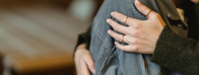 a person in grief hugging another person